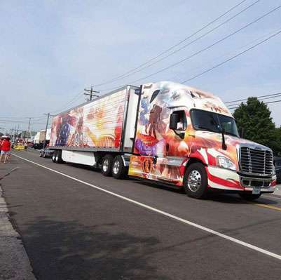 Veterans-themed Purdy Bros semi truck riding in a parade